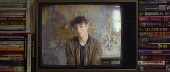 Movie still from “Climax” (2018), directed by Gaspar Noé – A young man sitting in front of an old tv screen; Close Up shot, Over the shoulder angle
