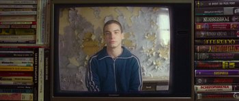 Movie still from “Climax” (2018), directed by Gaspar Noé – A young man is sitting in front of an old tv screen; Close Up shot, Low angle