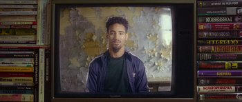 Movie still from “Climax” (2018), directed by Gaspar Noé – A man sitting in front of an old television screen; Medium shot, Over the shoulder angle