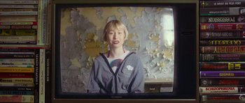 Movie still from “Climax” (2018), directed by Gaspar Noé – A woman is standing in front of an old tv screen; Medium shot, Over the shoulder angle