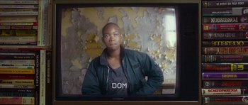 Movie still from “Climax” (2018), directed by Gaspar Noé – A man is standing in front of an old tv screen; Medium shot, Over the shoulder angle
