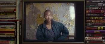 Movie still from “Climax” (2018), directed by Gaspar Noé – A man is standing in front of an old tv screen; Medium shot, Over the shoulder angle
