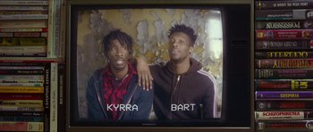 Movie still from “Climax” (2018), directed by Gaspar Noé – Two young men are posing for a picture on a television screen; Medium shot, Low angle