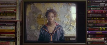 Movie still from “Climax” (2018), directed by Gaspar Noé – A woman is standing in front of an old tv screen; Close Up shot, Over the shoulder angle