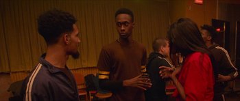 Movie still from “Climax” (2018), directed by Gaspar Noé – A group of people standing around in a room; Medium shot, Over the shoulder angle