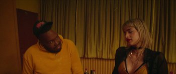 Movie still from “Climax” (2018), directed by Gaspar Noé – A man and a woman sitting at a table in front of a curtain; Close Up shot, Over the shoulder angle