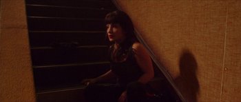 Movie still from “Climax” (2018), directed by Gaspar Noé – A woman sitting on the steps of a staircase; Medium shot, High angle