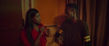 Movie still from “Climax” (2018), directed by Gaspar Noé – A man and a woman standing next to each other holding drinks; Medium shot, Over the shoulder angle