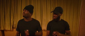 Movie still from “Climax” (2018), directed by Gaspar Noé – A couple of men wearing black shirts and hats; Medium shot, Over the shoulder angle