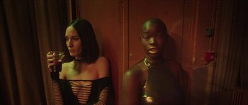 Movie still from “Climax” (2018), directed by Gaspar Noé – Two women standing next to each other in front of a wooden wall; Medium shot, Low angle
