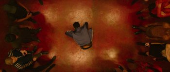 Movie still from “Climax” (2018), directed by Gaspar Noé – A man sitting on the ground in the middle of a room; Wide shot, Overhead angle