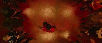 Movie still from “Climax” (2018), directed by Gaspar Noé – A person is sitting on the ground in a red shirt; Extreme Wide shot, Overhead angle