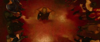 Movie still from “Climax” (2018), directed by Gaspar Noé – A man sitting on the ground with his hands on his knees; Wide shot, Overhead angle