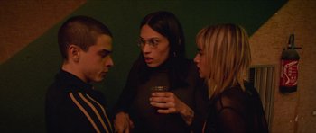 Movie still from “Climax” (2018), directed by Gaspar Noé – A woman holding a glass talking to two other people; Medium shot, Over the shoulder angle