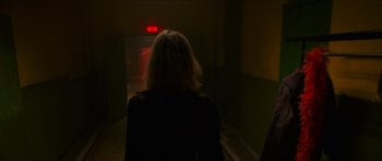 Movie still from “Climax” (2018), directed by Gaspar Noé – A woman in black jacket walking down a dark hallway; Medium shot, Low angle