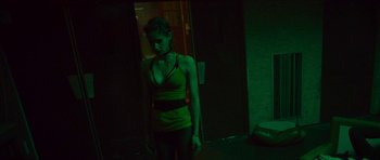 Movie still from “Climax” (2018), directed by Gaspar Noé – A woman standing in a dark room wearing a green shirt; Medium shot, Low angle