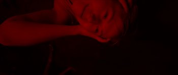 Movie still from “Climax” (2018), directed by Gaspar Noé – A woman laying on the ground with her head resting on her hand; Extreme Close Up shot, Overhead angle