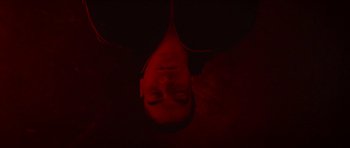 Movie still from “Climax” (2018), directed by Gaspar Noé – A man laying on the ground with his head upside down; Close Up shot, Overhead angle