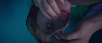 Movie still from “Climax” (2018), directed by Gaspar Noé – A woman is holding a pair of scissors up to her face; Extreme Close Up shot, Overhead angle