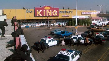 Movie still from “Cobra” (1986), directed by George P. Cosmatos – A parking lot filled with lots of police cars; Extreme Wide shot, Low angle