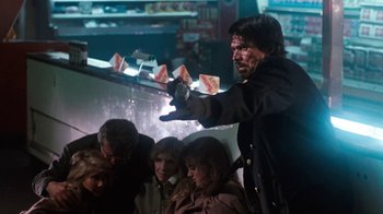 Movie still from “Cobra” (1986), directed by George P. Cosmatos – A group of people sitting in front of a man; Medium shot, Low angle
