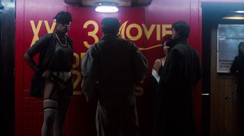 Movie still from “Cobra” (1986), directed by George P. Cosmatos – A group of people standing in front of a movie theater sign; Wide shot, Low angle