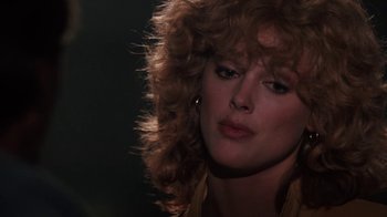 Movie still from “Cobra” (1986), directed by George P. Cosmatos – A person with a curly hair style; Close Up shot, Over the shoulder angle