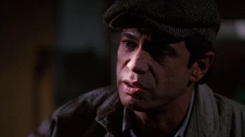 Movie still from “Cobra” (1986), directed by George P. Cosmatos – A person wearing a hat; Close Up shot, Over the shoulder angle