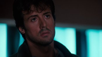 Movie still from “Cobra” (1986), directed by George P. Cosmatos – A person looking at the camera; Close Up shot, Low angle