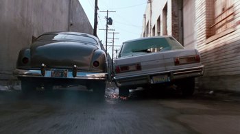 Movie still from “Cobra” (1986), directed by George P. Cosmatos – A couple of cars parked on the side of the street; Wide shot, Overhead angle