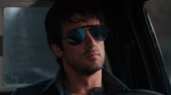 Movie still from “Cobra” (1986), directed by George P. Cosmatos – A person wearing sunglasses; Close Up shot, Low angle