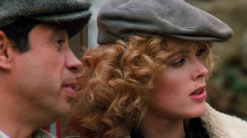 Movie still from “Cobra” (1986), directed by George P. Cosmatos – A man and a woman with curly hair wearing hats; Close Up shot, Over the shoulder angle