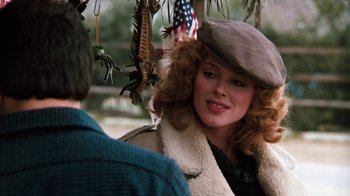 Movie still from “Cobra” (1986), directed by George P. Cosmatos – A person wearing a hat near a tree; Close Up shot, Over the shoulder angle