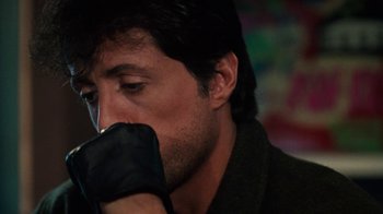 Movie still from “Cobra” (1986), directed by George P. Cosmatos – A person wearing a glove; Close Up shot, Over the shoulder angle