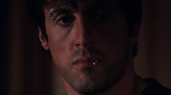 Movie still from “Cobra” (1986), directed by George P. Cosmatos – A person with a cigarette in his mouth; Close Up shot, Low angle