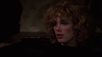 Movie still from “Cobra” (1986), directed by George P. Cosmatos – A person sitting in a room; Close Up shot, Over the shoulder angle