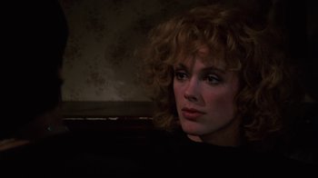 Movie still from “Cobra” (1986), directed by George P. Cosmatos – A person with curly red hair; Close Up shot, Over the shoulder angle