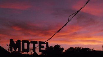 Movie still from “Cobra” (1986), directed by George P. Cosmatos – A motel sign with a rope hanging from it's side; Extreme Wide shot, Low angle