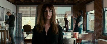 Movie still from “Colossal” (2016), directed by Nacho Vigalondo – A woman standing in front of a window in a room; Medium shot, Over the shoulder angle