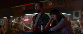 Movie still from “Colossal” (2016), directed by Nacho Vigalondo – A man and a woman sitting at a bar; Medium shot, Over the shoulder angle