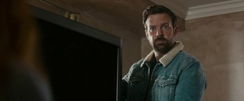 Movie still from “Colossal” (2016), directed by Nacho Vigalondo – A man with a beard wearing a jean jacket; Close Up shot, Over the shoulder angle