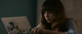 Movie still from “Colossal” (2016), directed by Nacho Vigalondo – A woman is looking at a laptop computer; Close Up shot, High angle