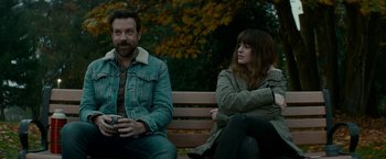 Movie still from “Colossal” (2016), directed by Nacho Vigalondo – A man and a woman sitting on a park bench; Medium shot, Over the shoulder angle