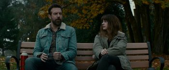Movie still from “Colossal” (2016), directed by Nacho Vigalondo – A man and a woman sitting on a park bench; Medium shot, Over the shoulder angle
