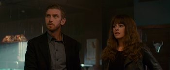 Movie still from “Colossal” (2016), directed by Nacho Vigalondo – A man and a woman standing next to each other in a room; Medium shot, Over the shoulder angle