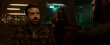 Movie still from “Colossal” (2016), directed by Nacho Vigalondo – A man and a woman are standing in a dark room; Close Up shot, Over the shoulder angle