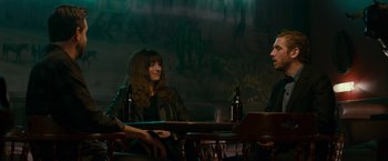 Movie still from “Colossal” (2016), directed by Nacho Vigalondo – Three people are sitting at a table with beer; Medium shot, Over the shoulder angle