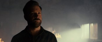 Movie still from “Colossal” (2016), directed by Nacho Vigalondo – A man with a goatee is looking into the distance; Close Up shot, Over the shoulder angle