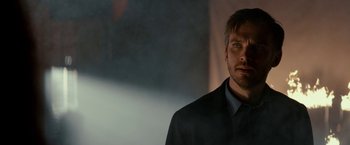 Movie still from “Colossal” (2016), directed by Nacho Vigalondo – A person wearing a suit and tie; Close Up shot, Over the shoulder angle