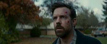 Movie still from “Colossal” (2016), directed by Nacho Vigalondo – A person with a face covered in blood; Close Up shot, Over the shoulder angle